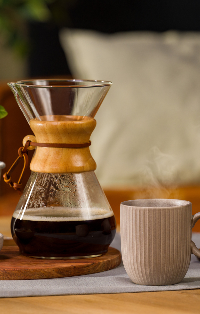 Chemex mit Kaffee darin, daneben eine Tasse