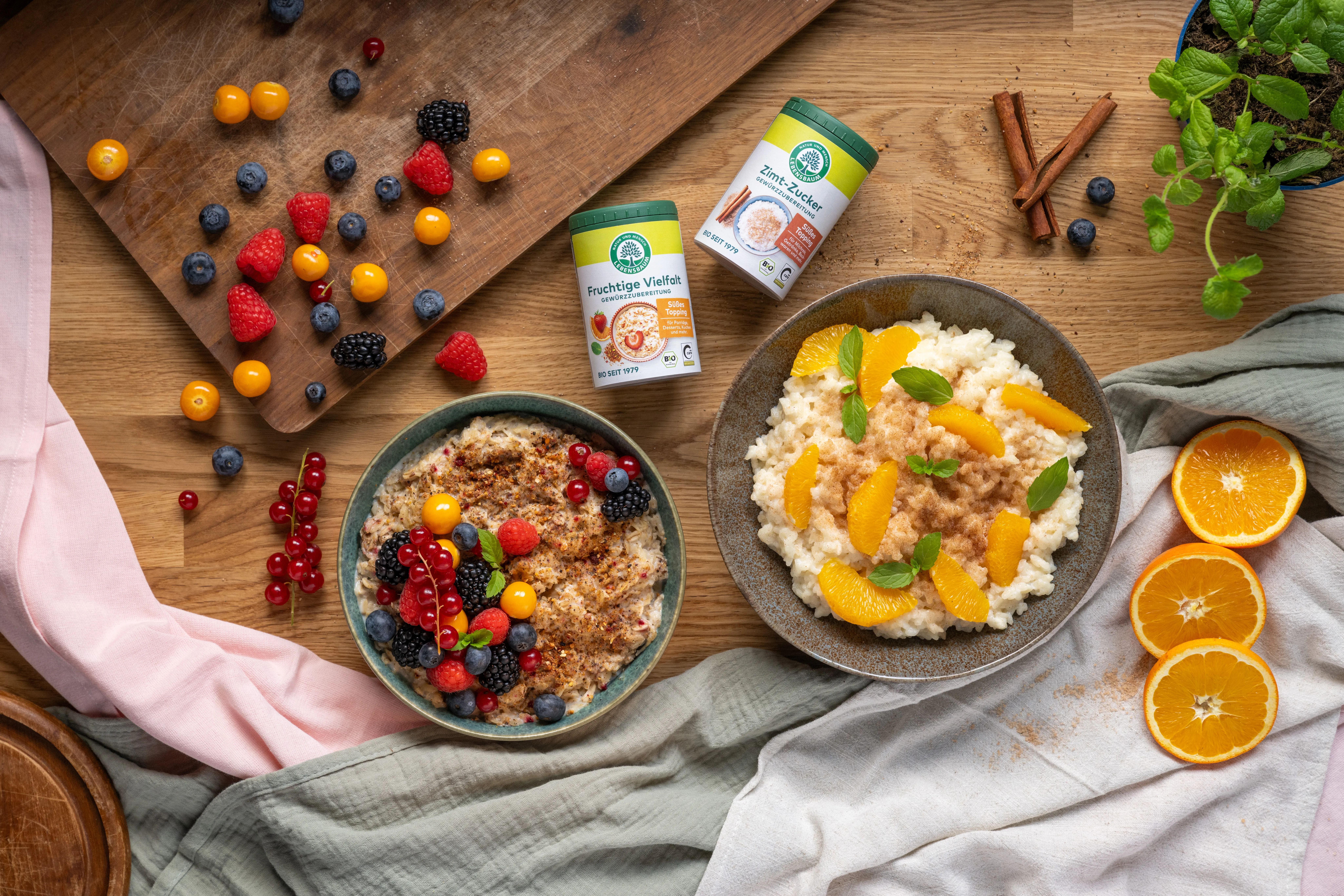 Toppings liegen auf einem Holztisch daneben liegen lose Beeren und zwei Schüsseln mit Essen