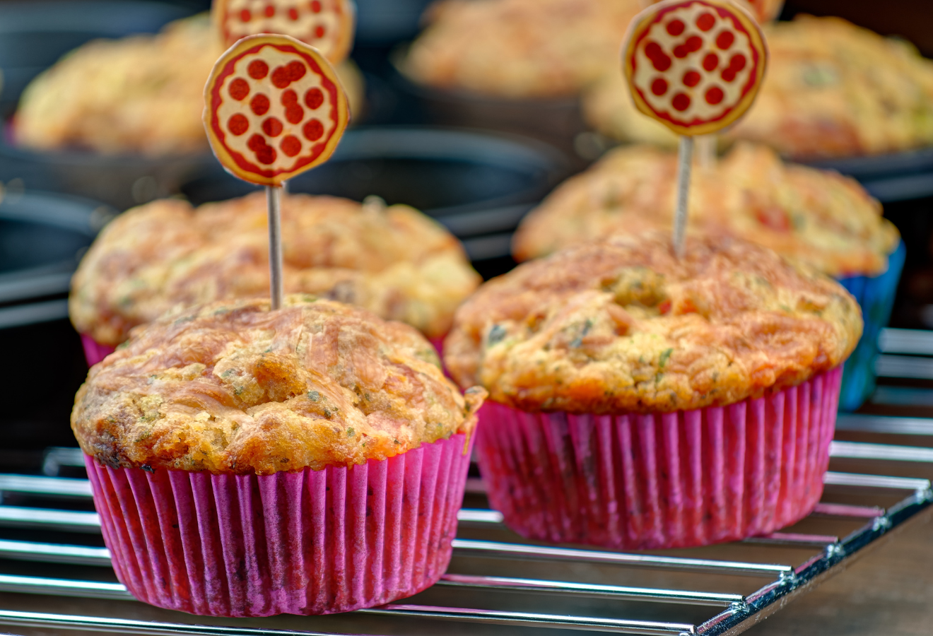 Pizzamuffins mit Deko in pinken Förmchen auf einem Gitter