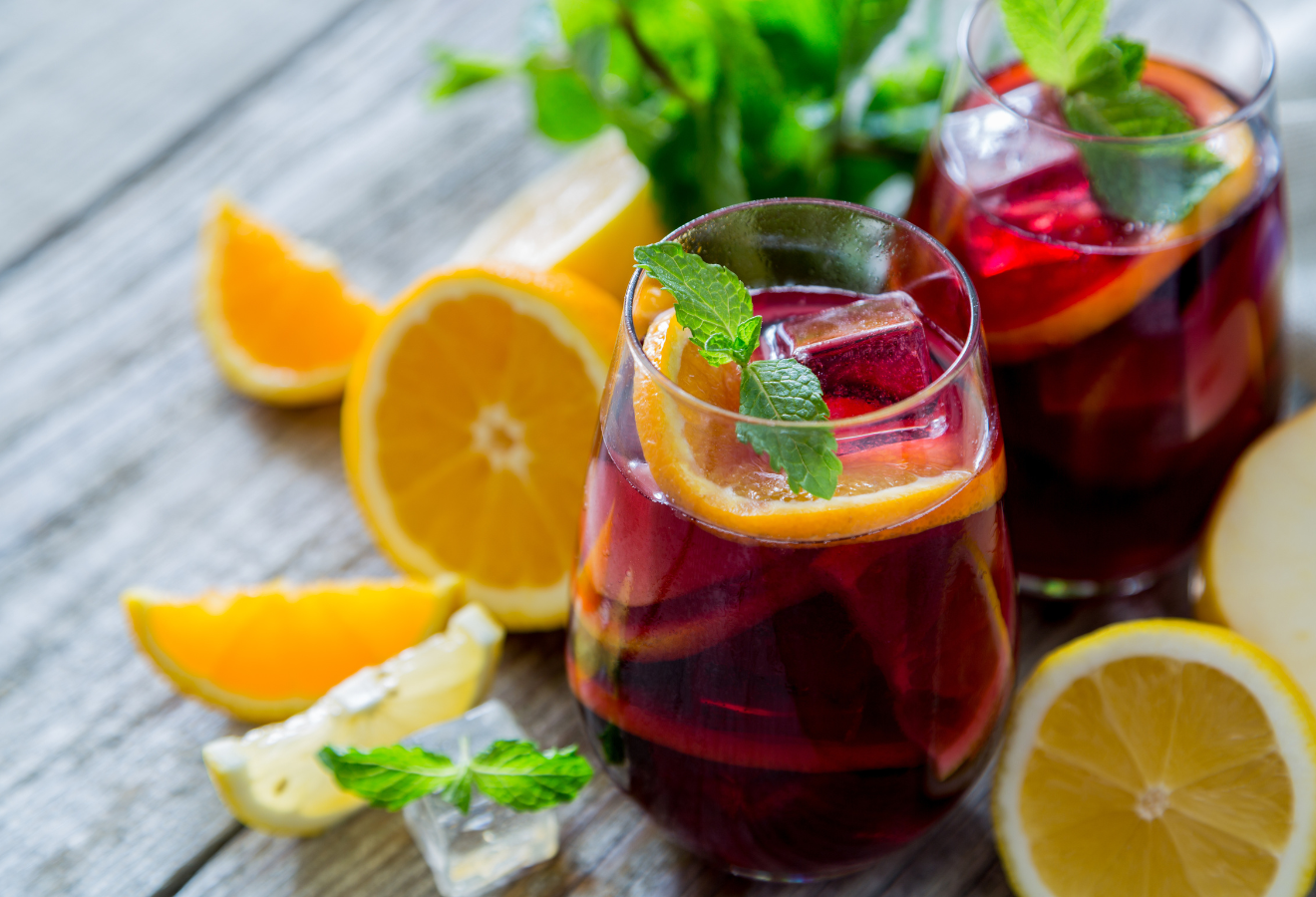 Leckermäulchen-Bowle in einem Glas mit Orangenscheiben und Minzblättern