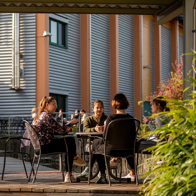 Menschen sitzen an einem Tisch im Außenbereich unseres Bistros