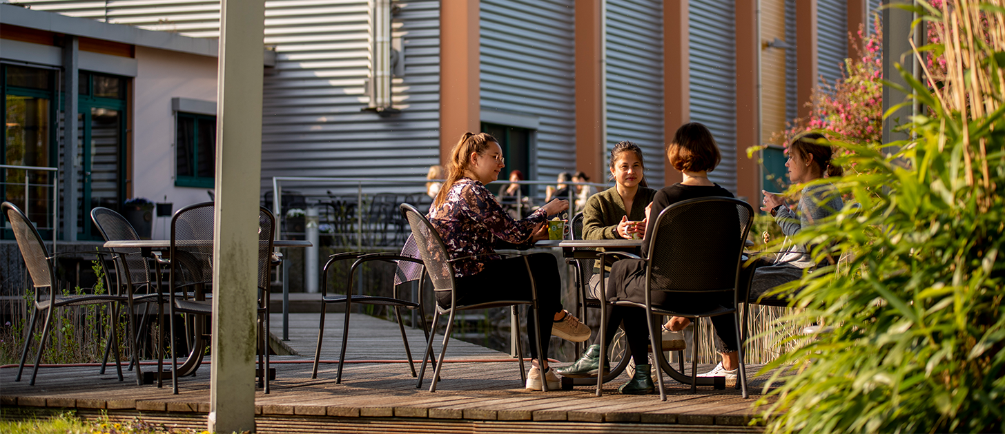 Menschen sitzen an einem Tisch im Außenbereich unseres Bistros in Diepholz