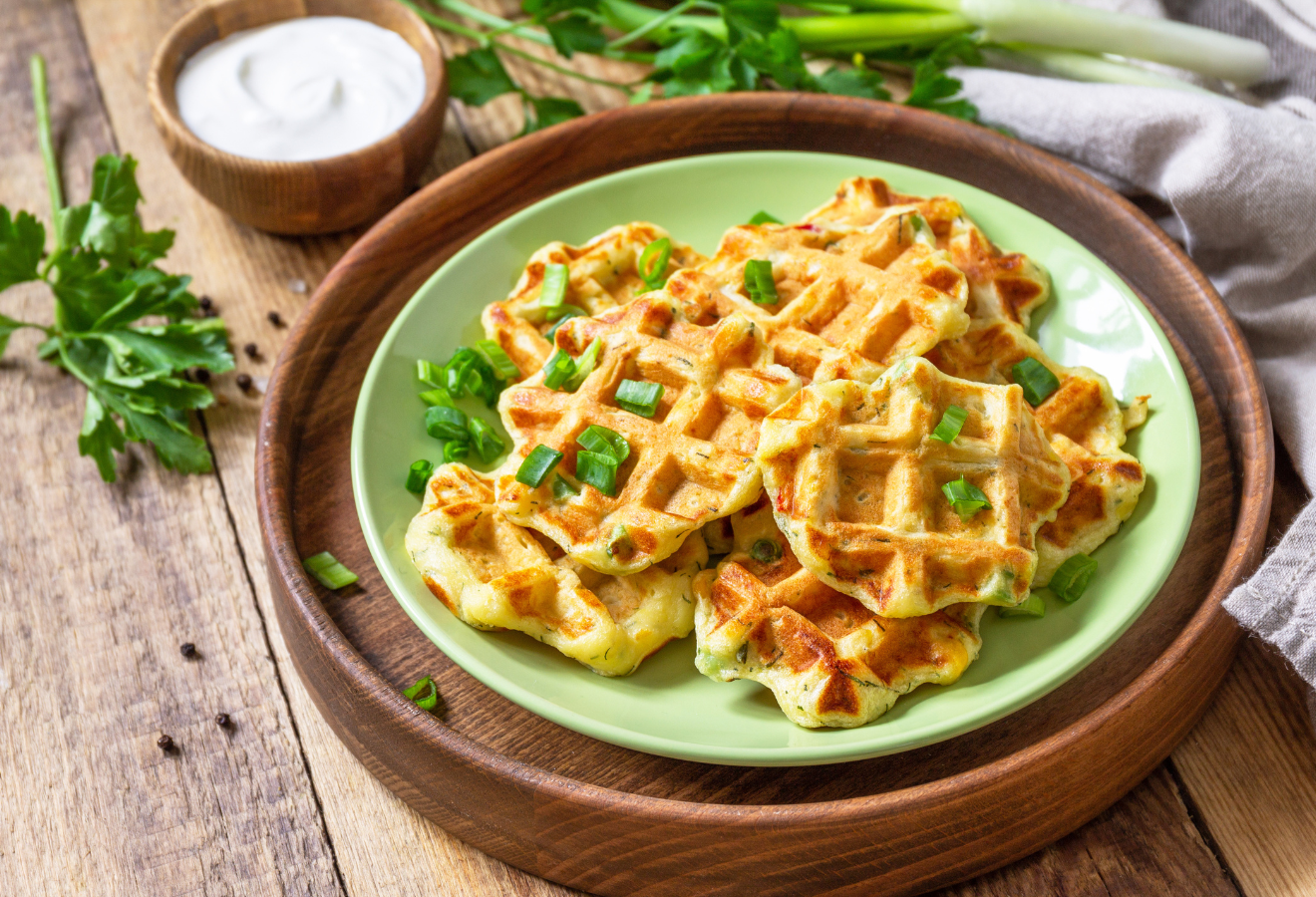 Kartoffel-Harissa-Waffeln auf einem Teller mit Frühlingszwiebeln dekoriert
