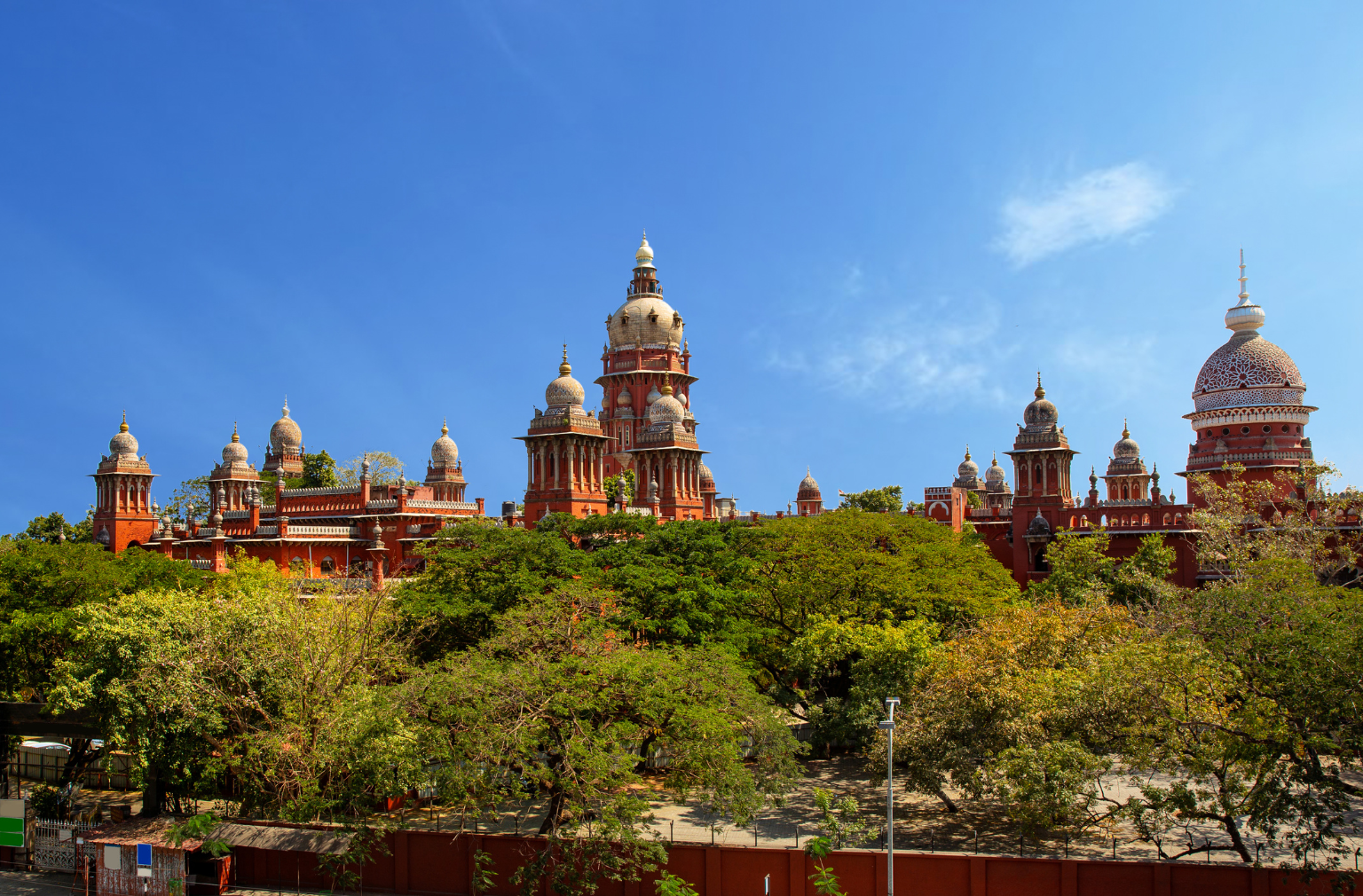  Madras High Court in Chennai mit vielen Kuppeln und Türmen hinter grünen Bäumen
