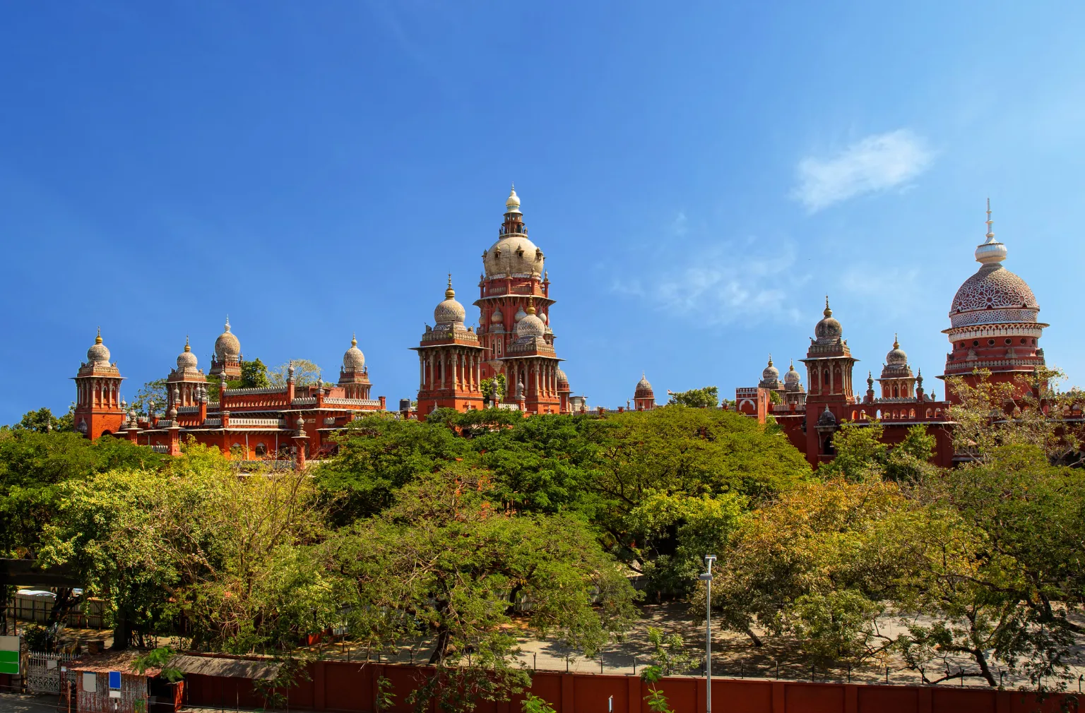  Madras High Court in Chennai mit vielen Kuppeln und Türmen hinter grünen Bäumen