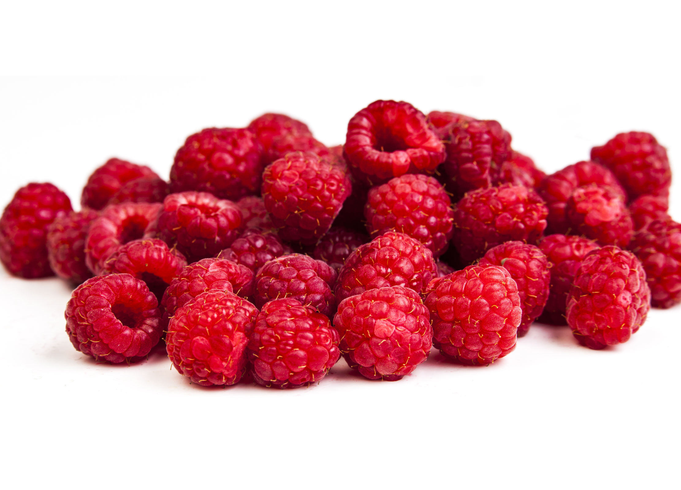 Himbeere Ein Haufen frischer, leuchtend roter Himbeeren mit feiner Struktur auf weißem Hintergrund