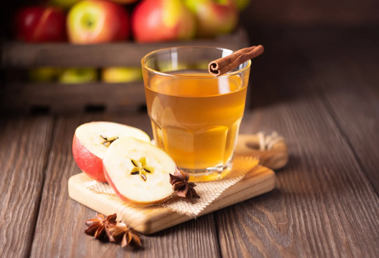 Winterlicher Apfel-Punsch-Likör in einem Glas mit Zimtstangen und Sternanis