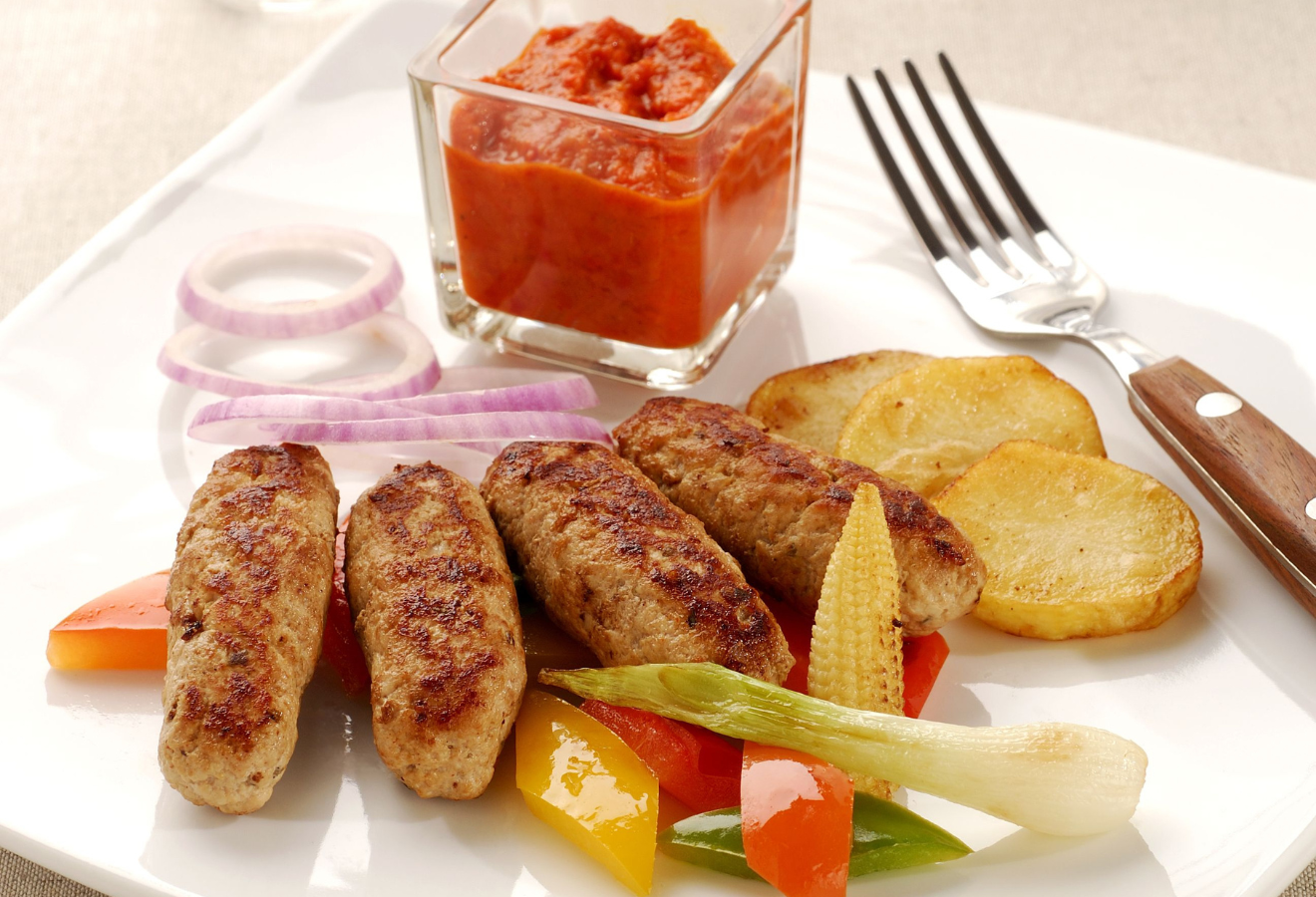 Chilichichi auf einem Teller, mit Kartoffeln, Gemüse und Salsa