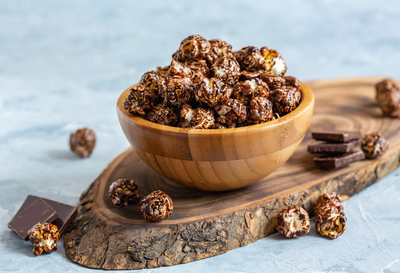 Schoko-Zimt-Popcorn in einem Holzschälchen auf einem Holzbrett