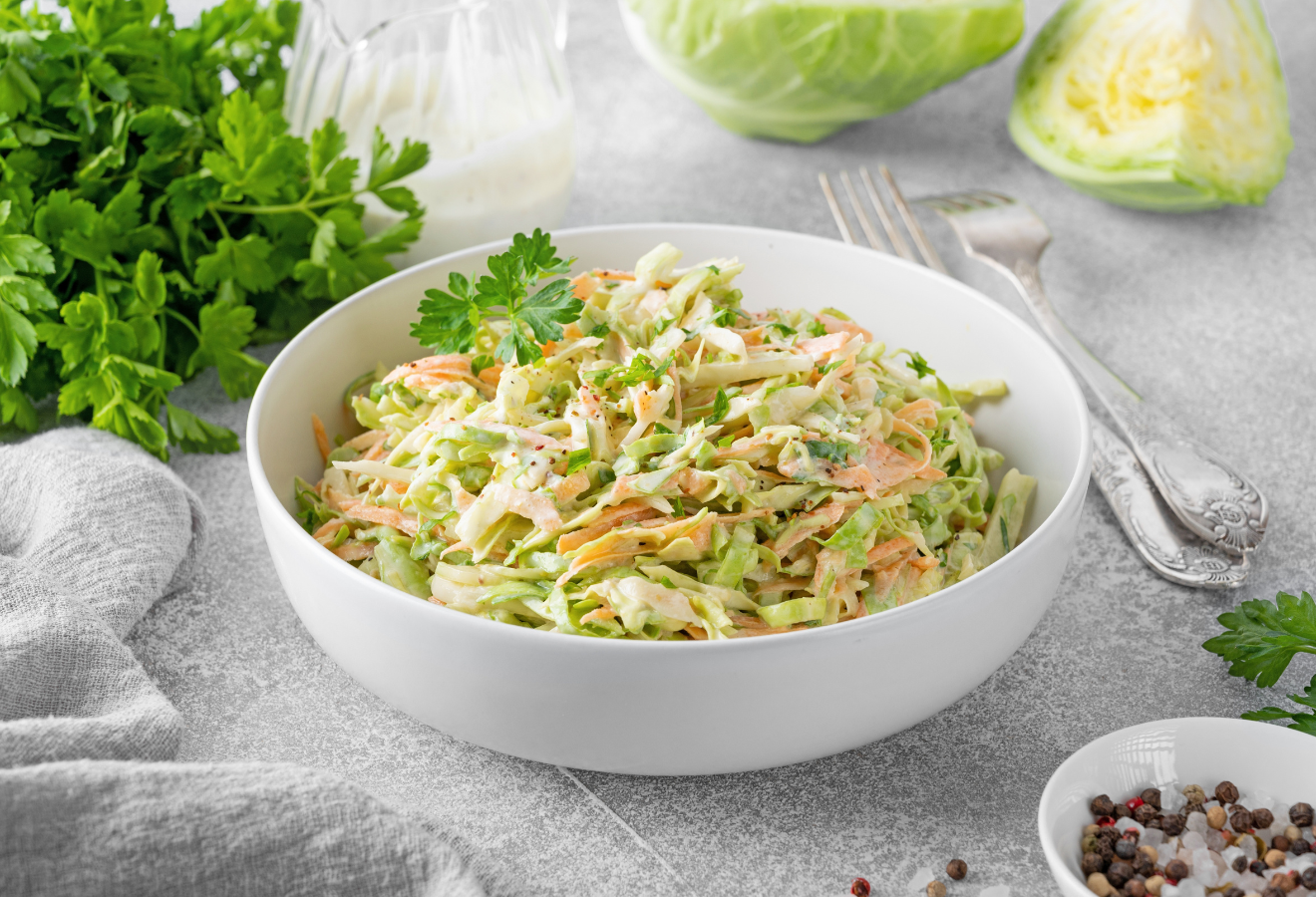 Orientalischer Cole Slaw in einer weißen Schale, daneben Gabeln