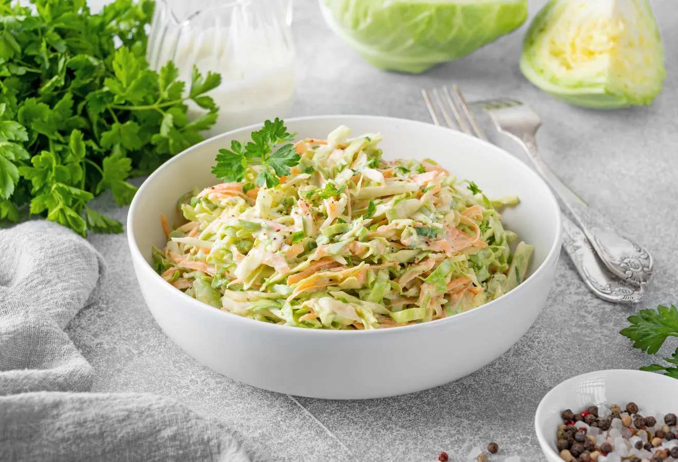 Orientalischer Cole Slaw in einer weißen Schale, daneben Gabeln