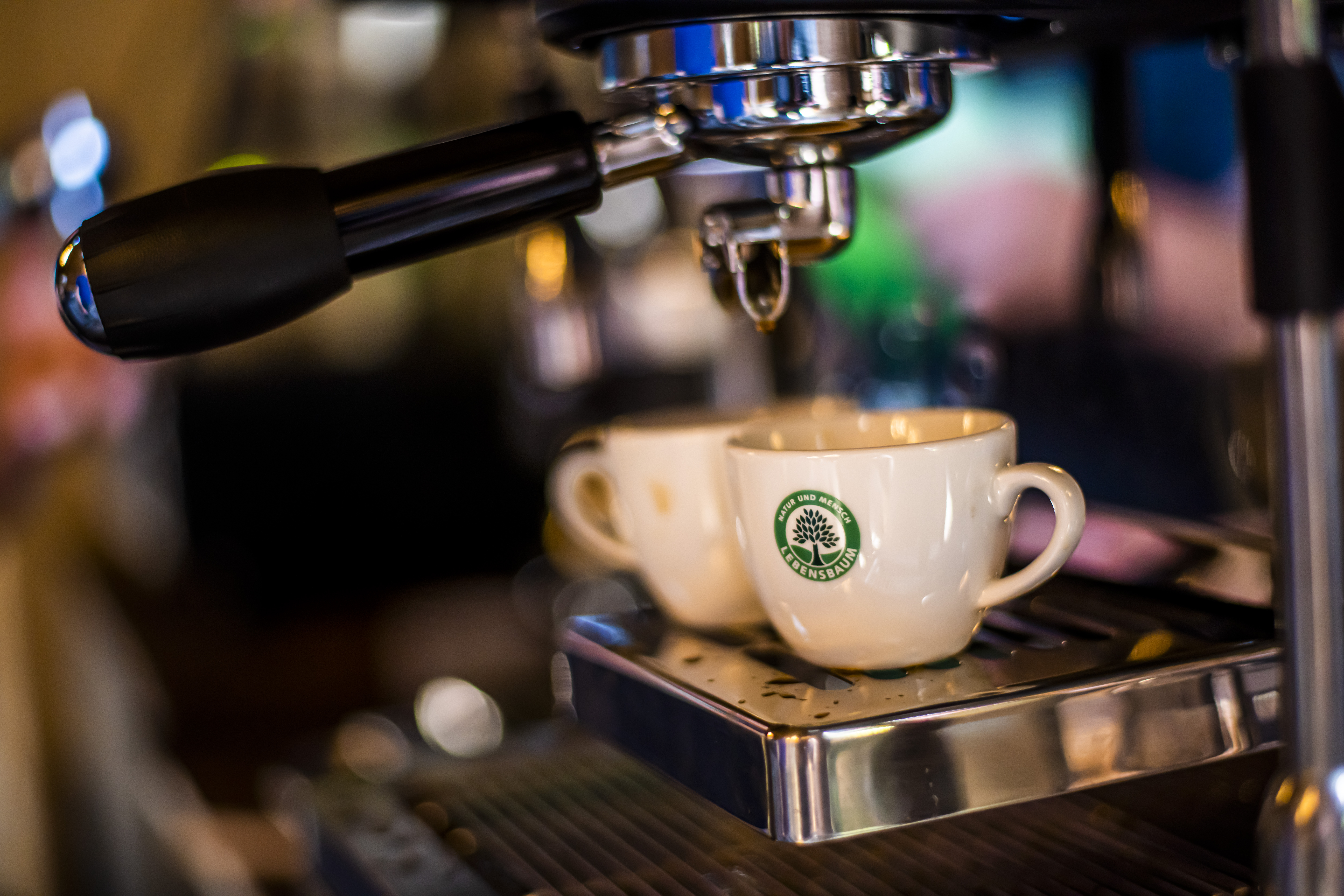 „Espressotassen von Lebensbaum auf Siebträgermaschine bei der Kaffeezubereitung