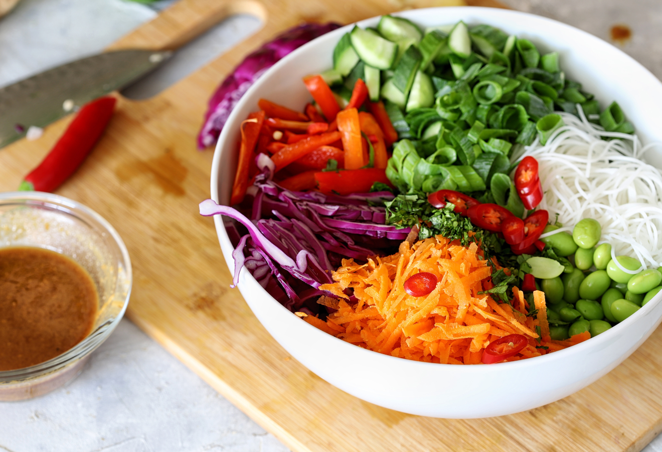 Glasnudelsalat in einer weißen Schüssel auf einem Holzbrett