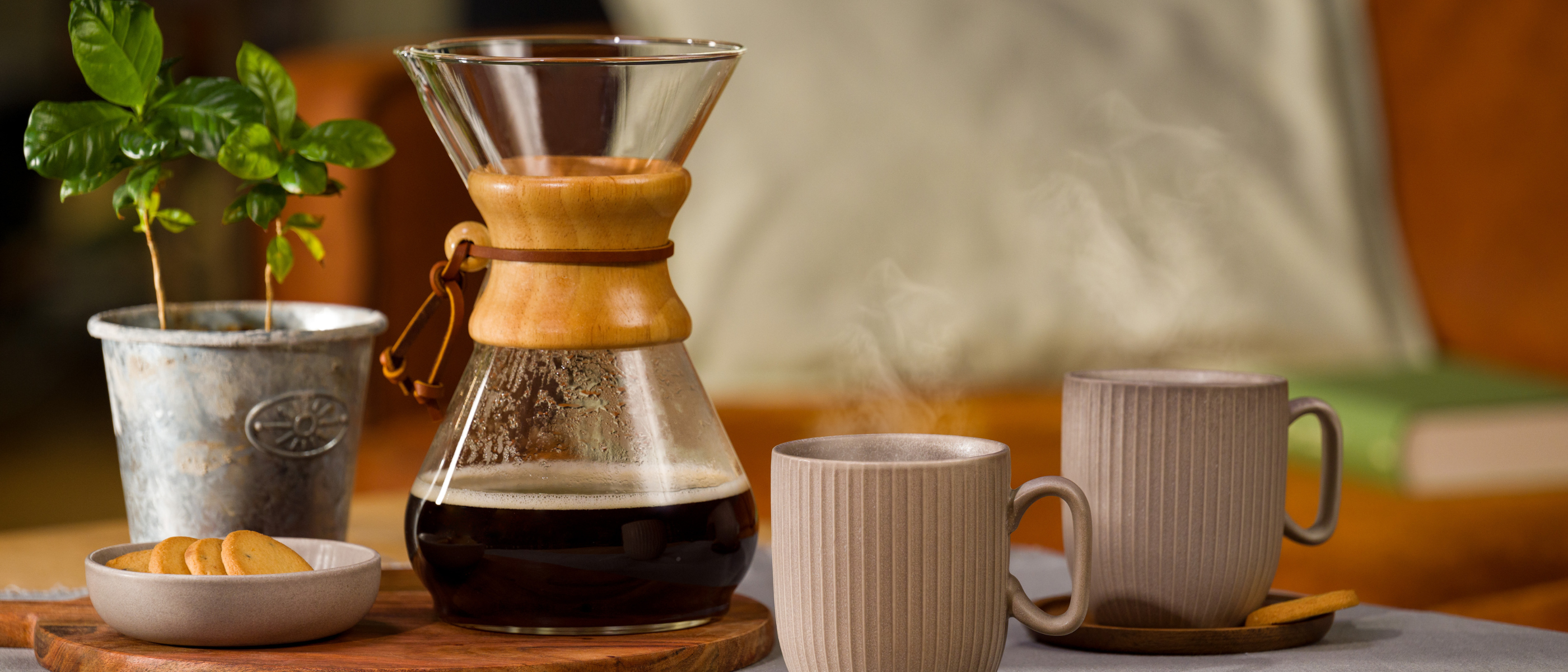 Chemex mit Kaffee darin und zwei Tassen davor