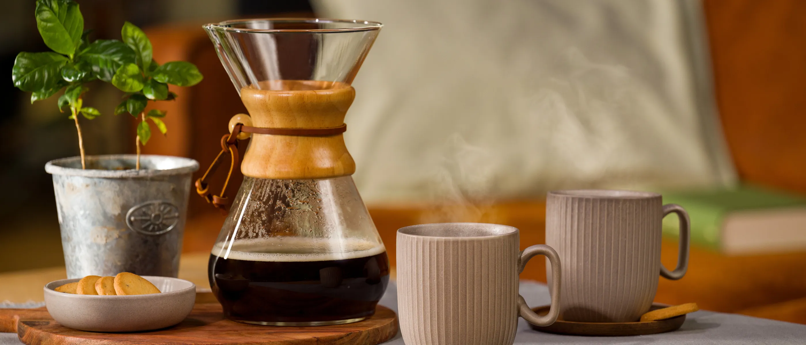 Chemex mit Kaffee darin und zwei Tassen davor