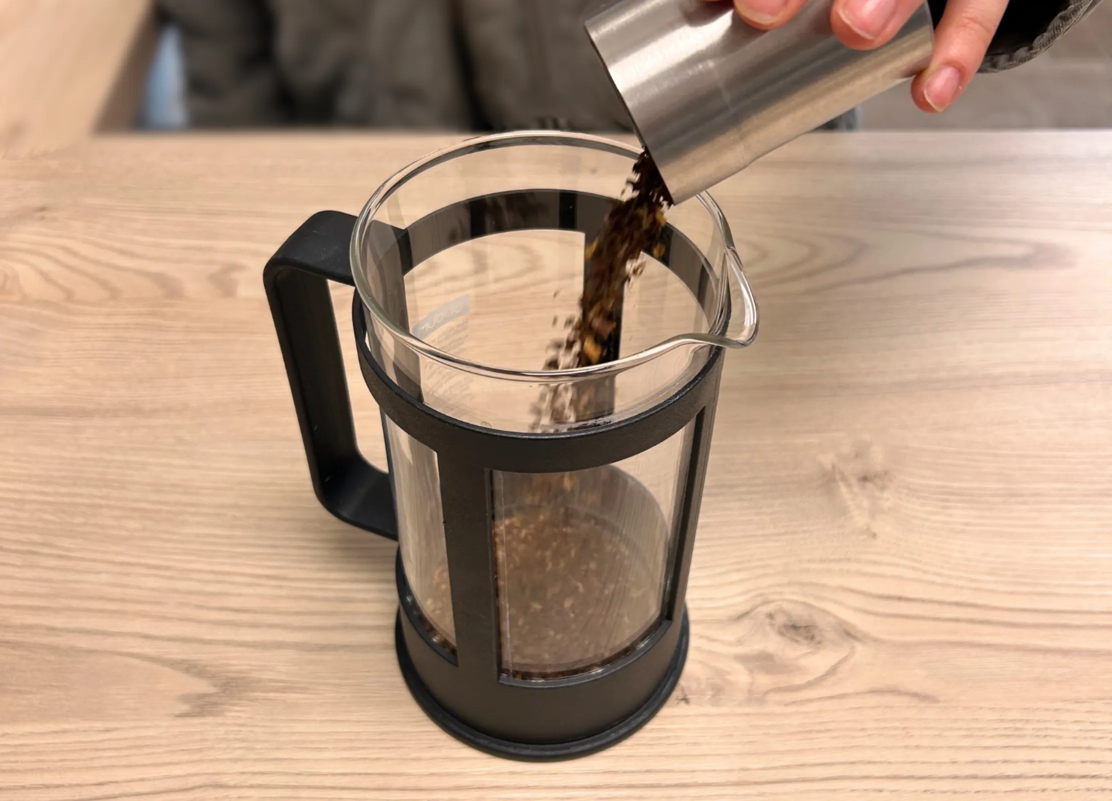 Gemahlener Kaffee wird in eine French Press aus Glas gefüllt