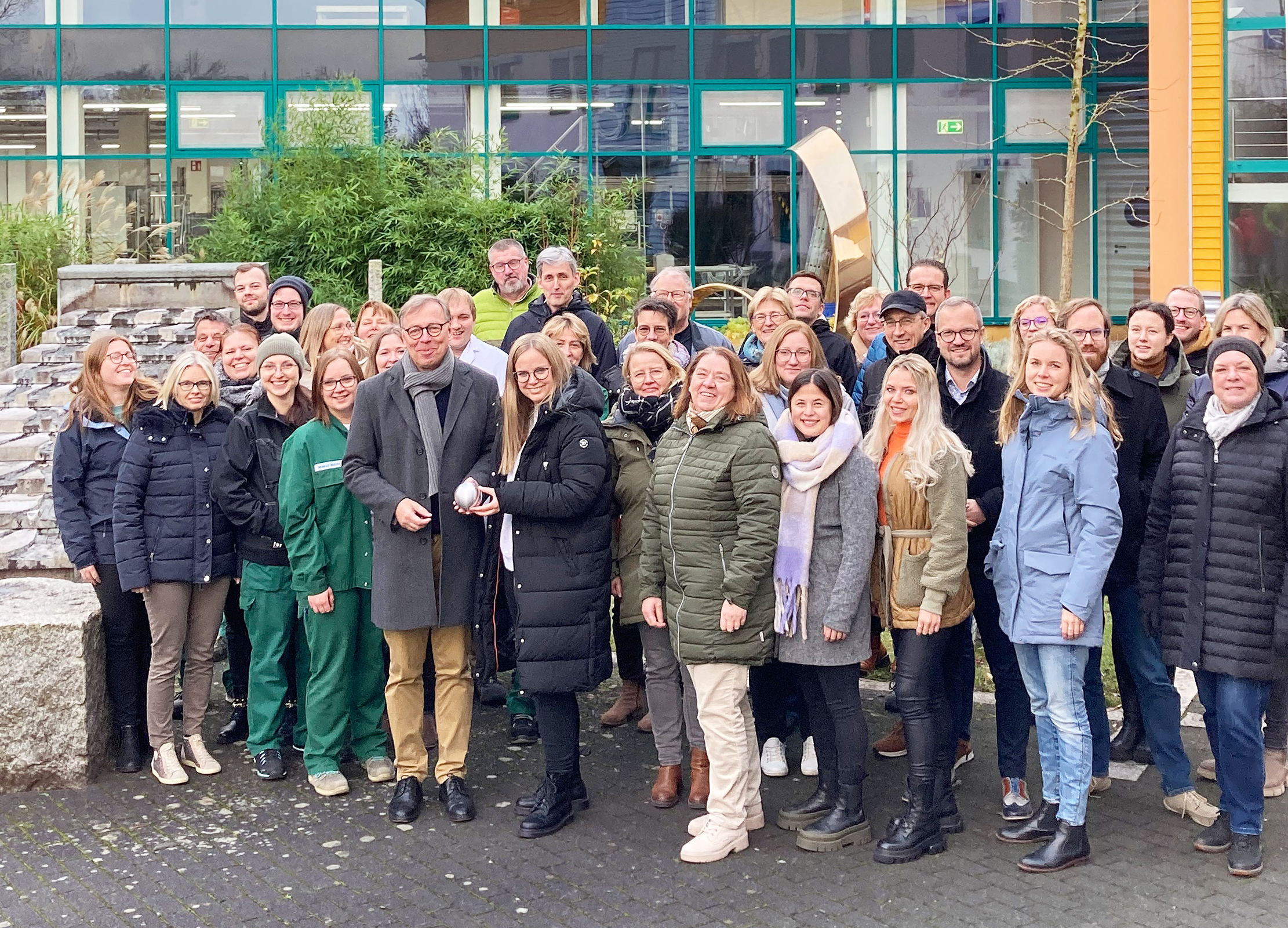 Gruppenfoto von Mitarbeitenden vor dem Gebäude der Firma Lebensbaum