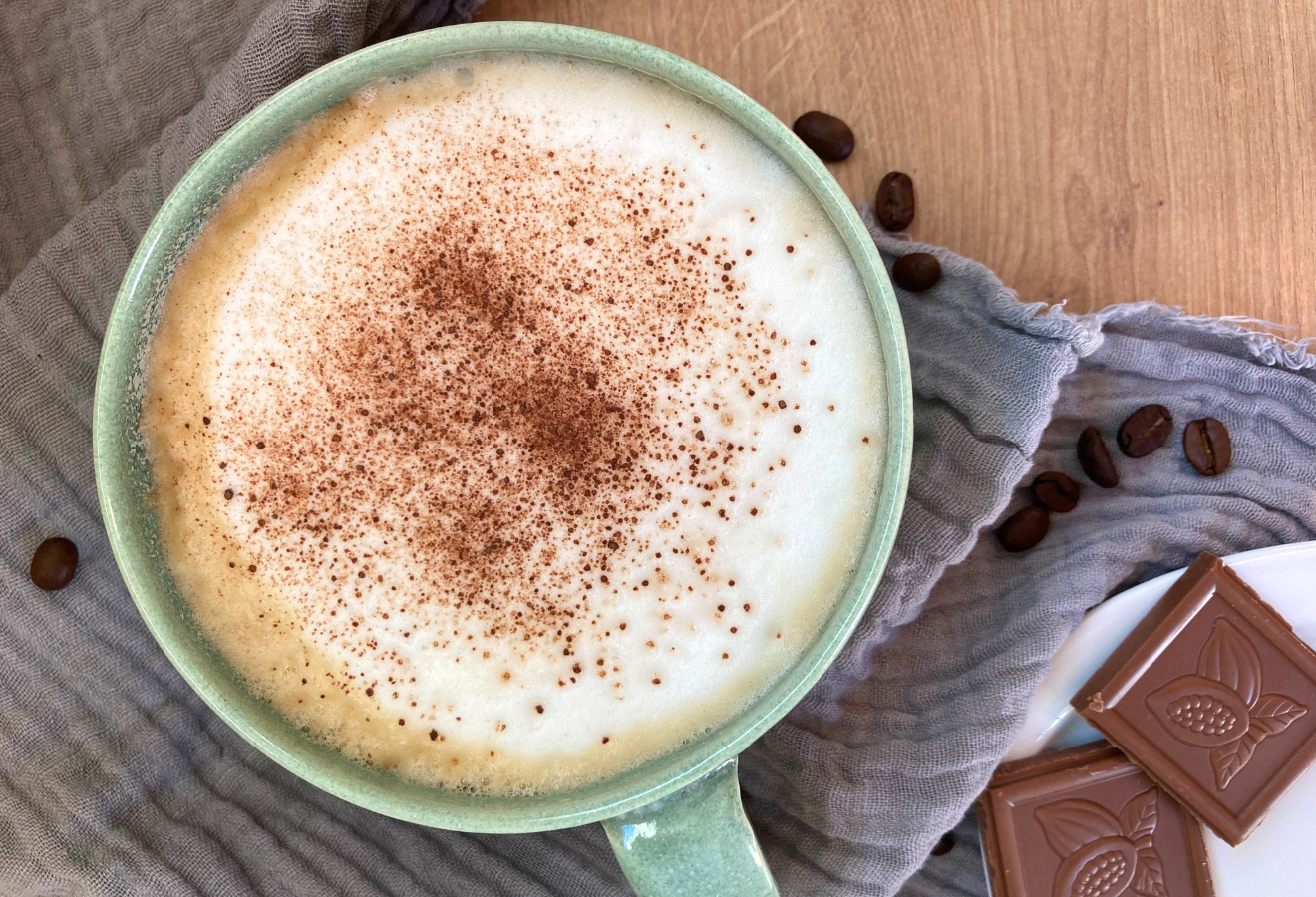 Chococcino in einer Tasse mit Kakaopulver bestreut