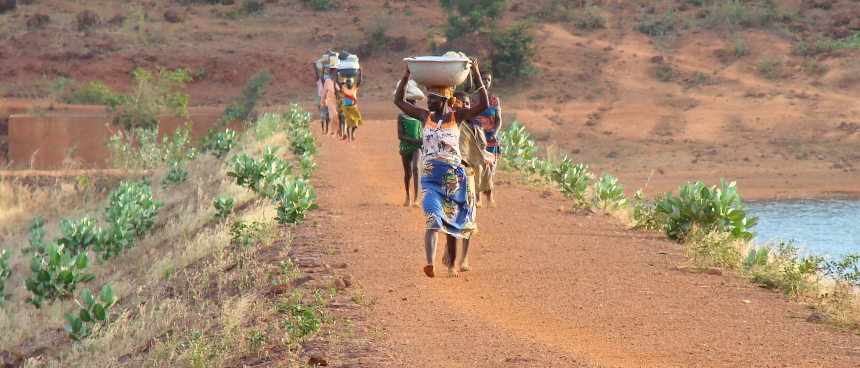 Bild aus Burkina Faso mit Menschen, die Wasserschalen tragen