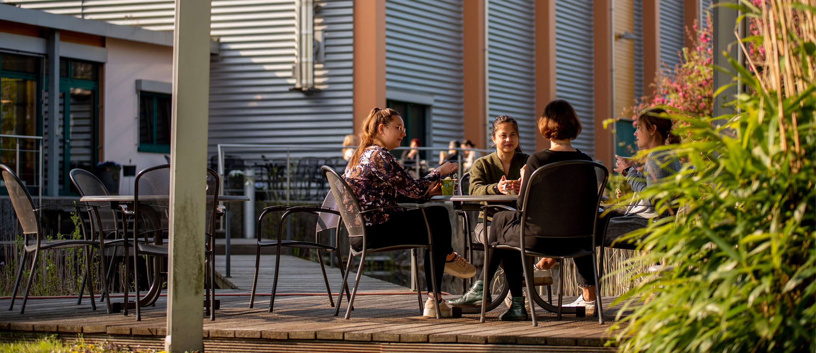 Menschen sitzen an einem Tisch im Außenbereich unseres Bistros