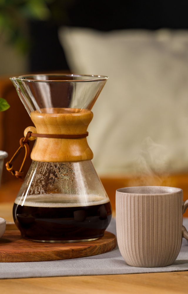 Chemex mit Kaffee darin, daneben eine Tasse