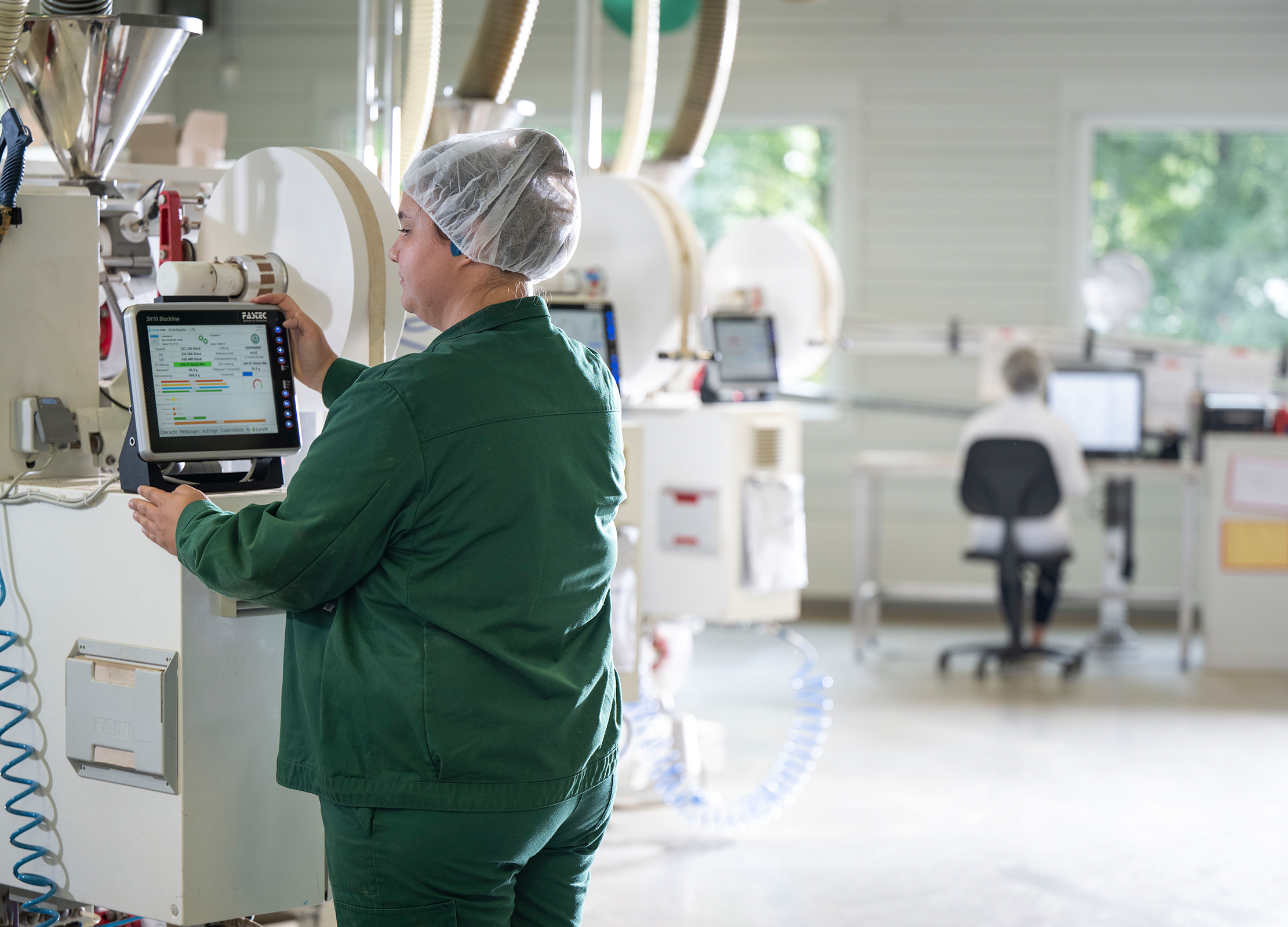 Produktionsmitarbeiterin von Lebensbaum arbeitet an einer Teemaschine