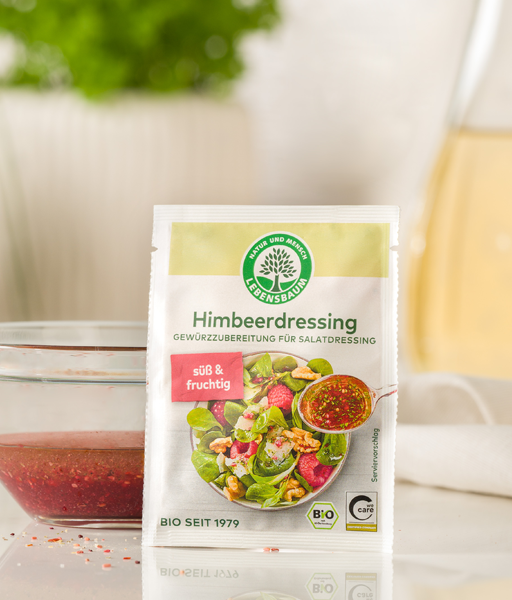 Ketagoriebild für Salatdressings, Himbeeredressing-Verpackung neben einer kleinen Schüssel mit dem fertig angerührten pinken Dressing