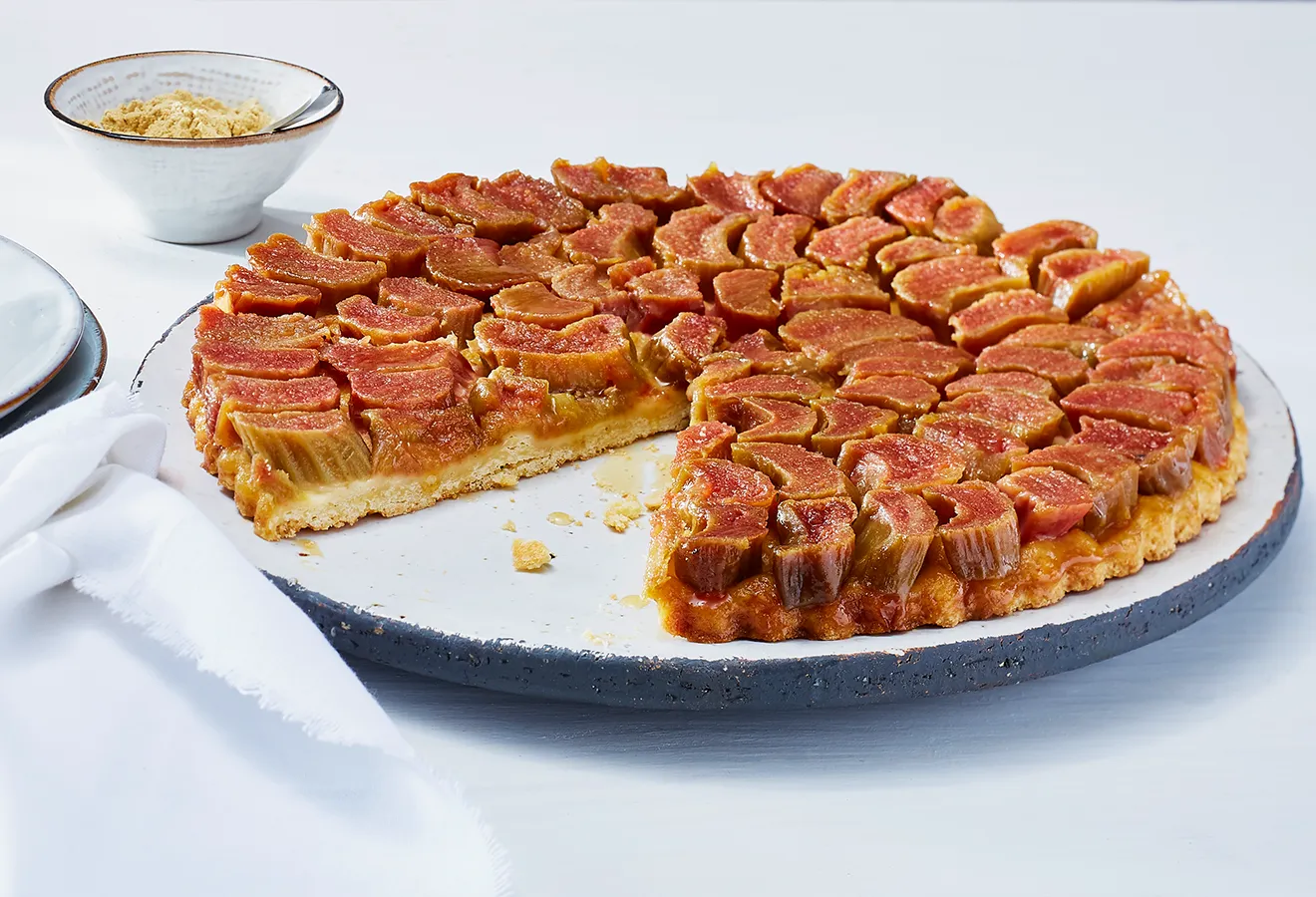 Tarte Tartin mit Rhabarber und Ingwer auf einem weißen Kuchenteller