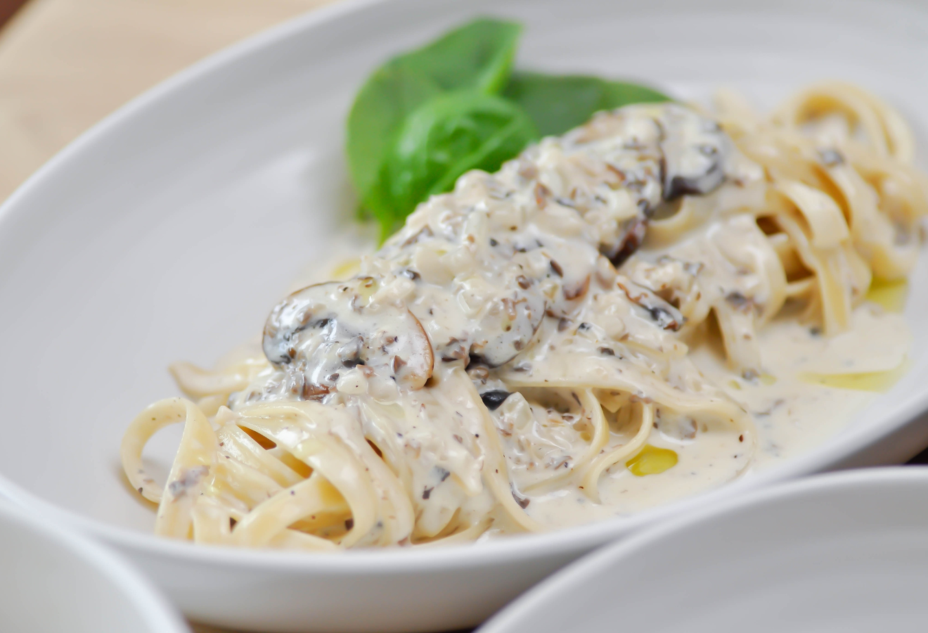 Spaghetti mit Pilz-Salbei Carbonara in einer weißen Schale