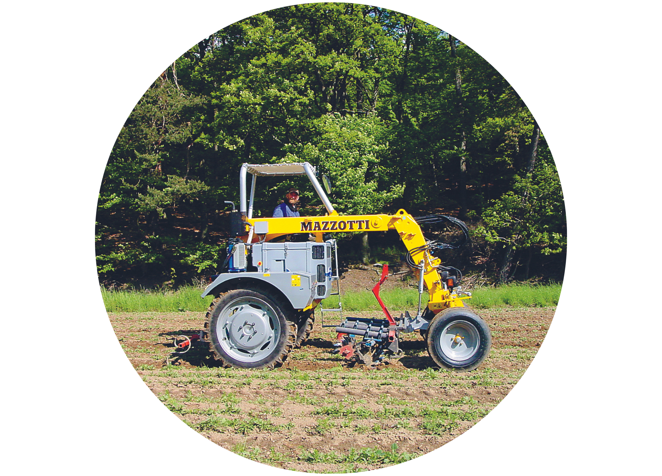 Gelb-grauer Spezialtraktor der Marke Mazzotti auf einem Feld vor einem Waldrand