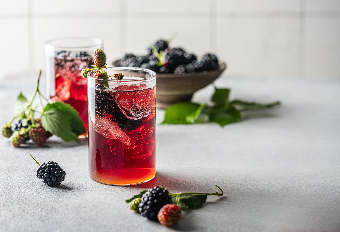 Spätsommer-Bowle für Süßschnäbel in zwei Gläsern, dahinter Brombeeren