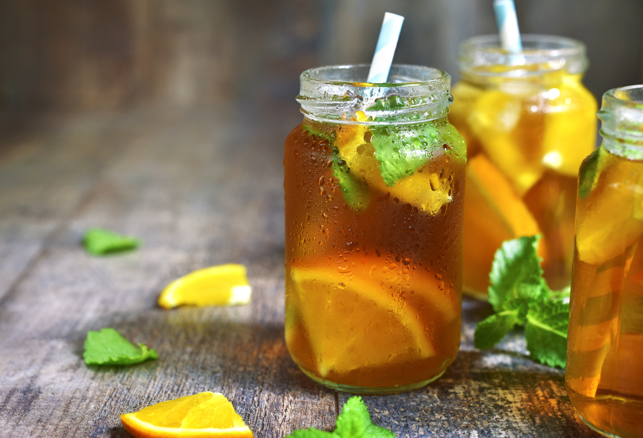 Bärenstarker Eistee, erfrischend mit Orangenscheiben im Glas