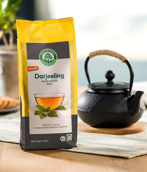 Kategoriebild für LEBENSBAUM Schwarztee, Darjeeling loser Tee Verpackung neben einer traditionellen Teekanne