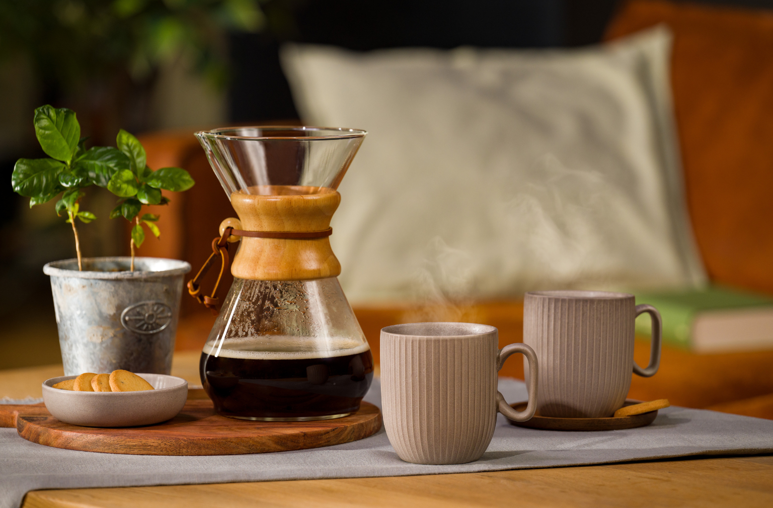 Chemex mit Kaffee darin, daneben zwei Tassen