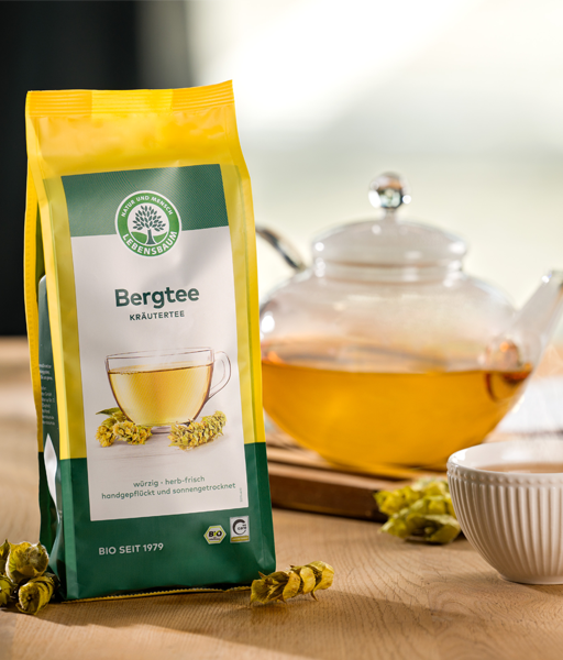 Kategoriebild für Kräutertee und Kräuterteemischungen von LEBENSBAUM, Bergtee-Verpackung neben sideriatis scardica und einer Teekaffe mit leuchtendem und dampfendem Tee in einer Kanne
