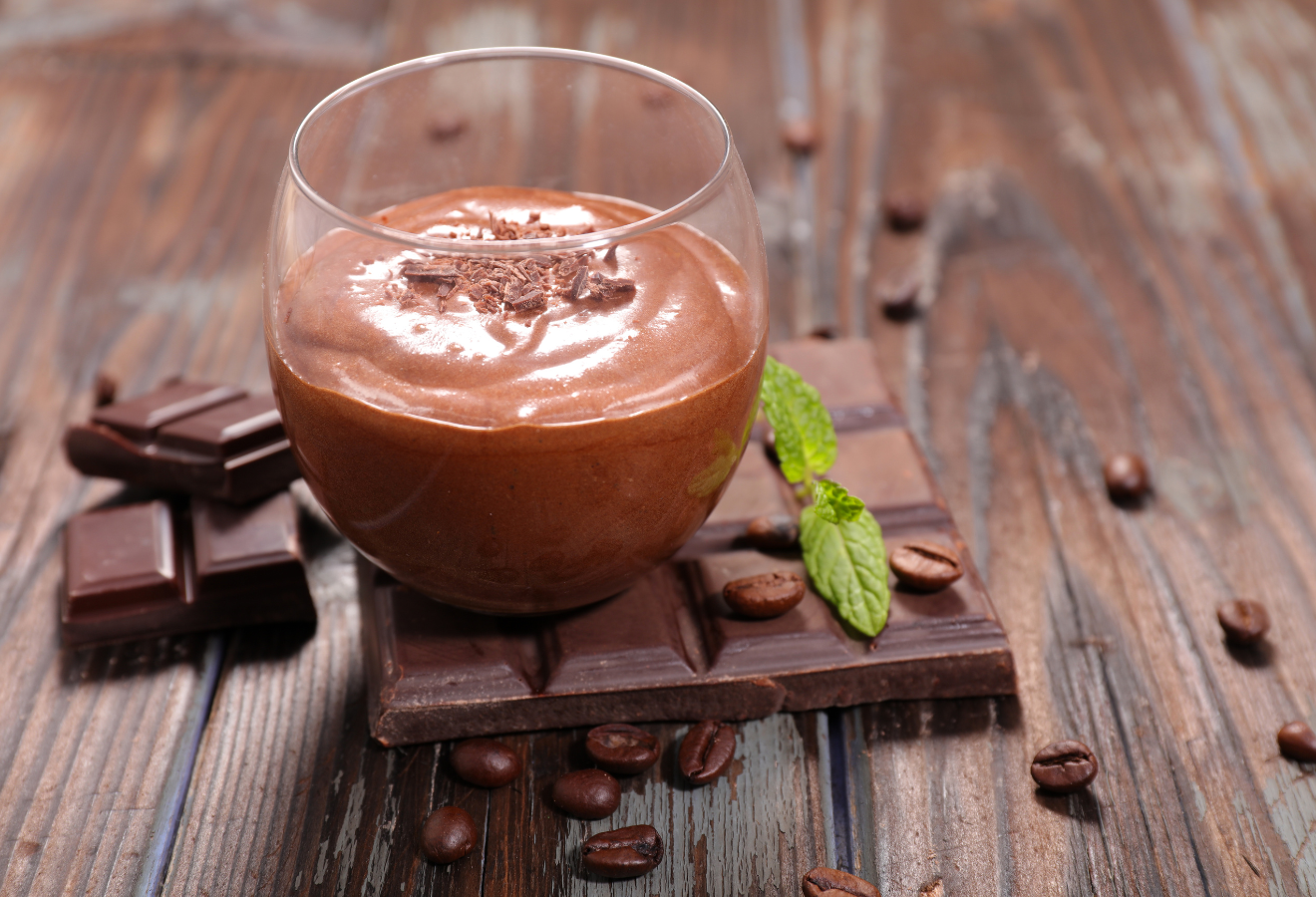 Mousse au chocolat mit zarter Kaffeenote in einem Glas auf einer Tafel Schokolade