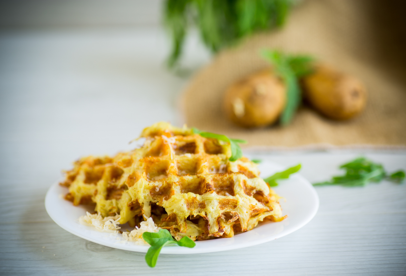Ferdis Kartoffelpuffer aus dem Waffeleisen auf einem Teller mit Parmesan bestreut