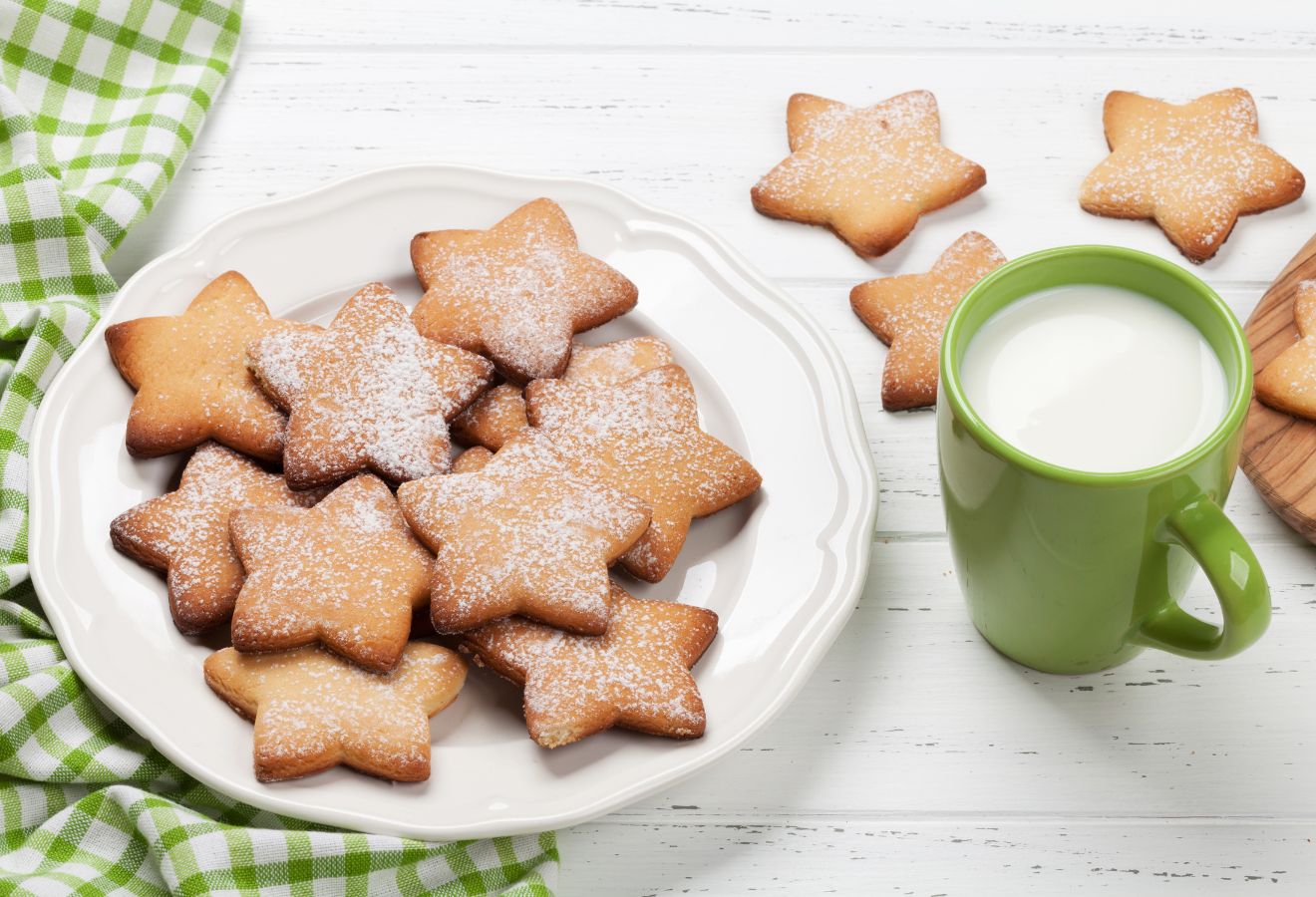 Lebkuchen-Plätzchen auf einem weißen Teller, daneben eine Tasse mit Milch