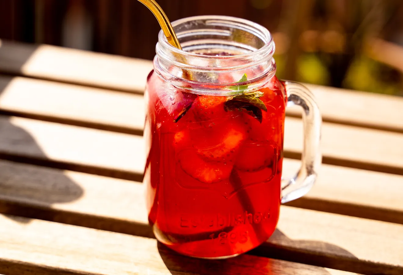 Beeren-Waldmeister-Bowle, erfrischen, spritzig, im Glas mit Erdbeerscheiben