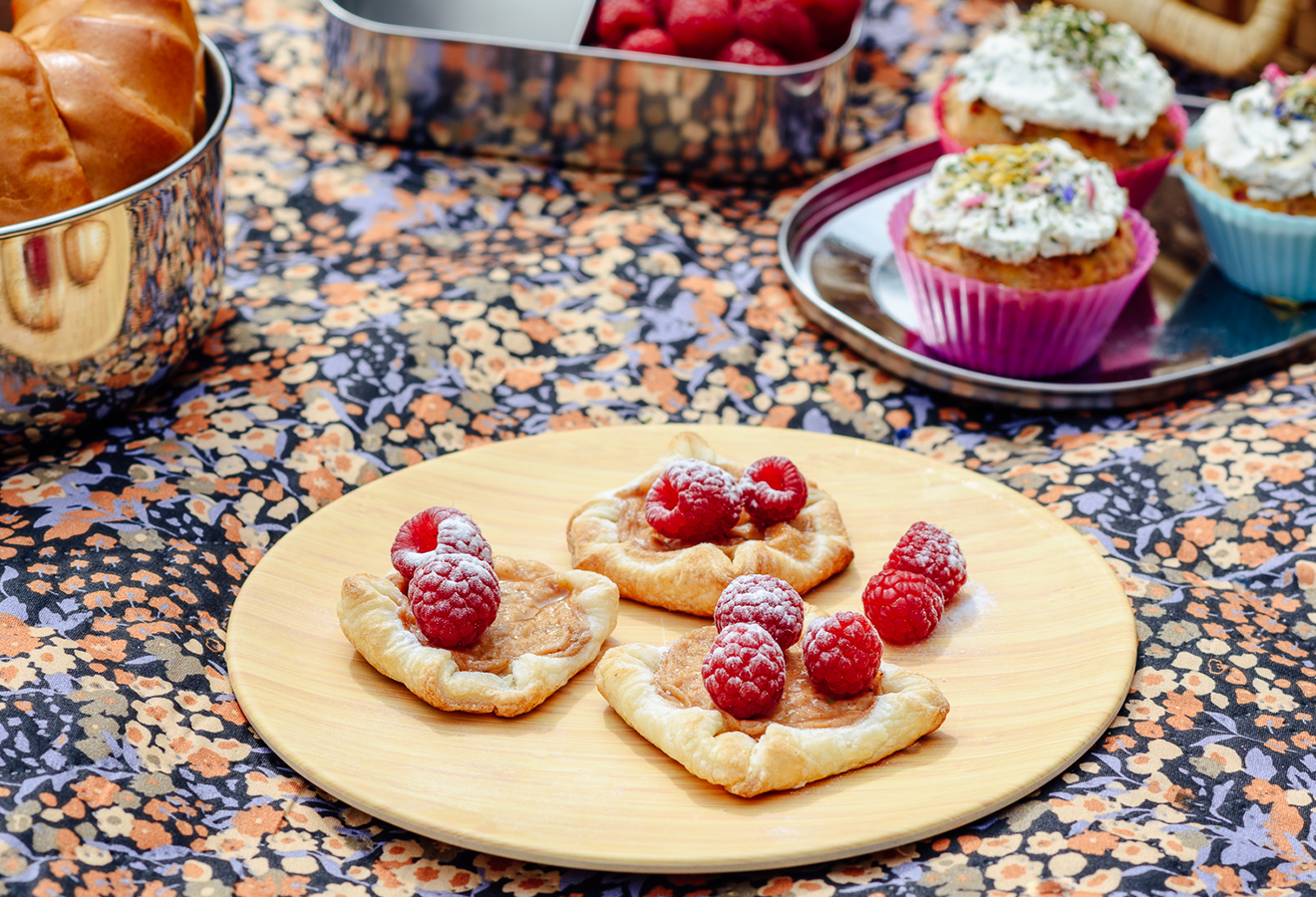 Blätterteig-Teilchen mit Himbeeren getoppt auf einem Brett