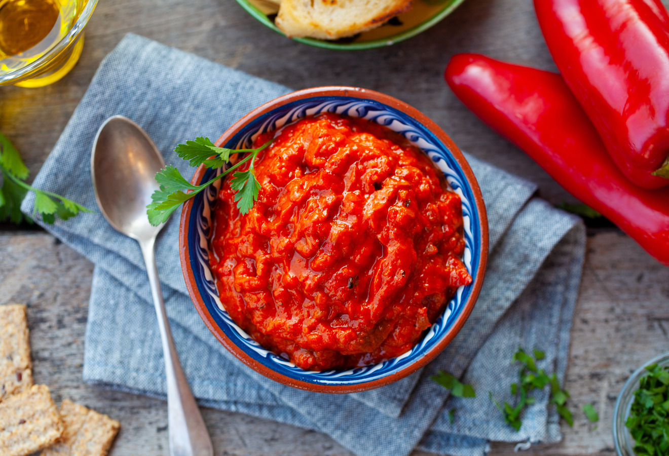 Tomaten-Relish in einer blauen Schale, daneben ein Löffel