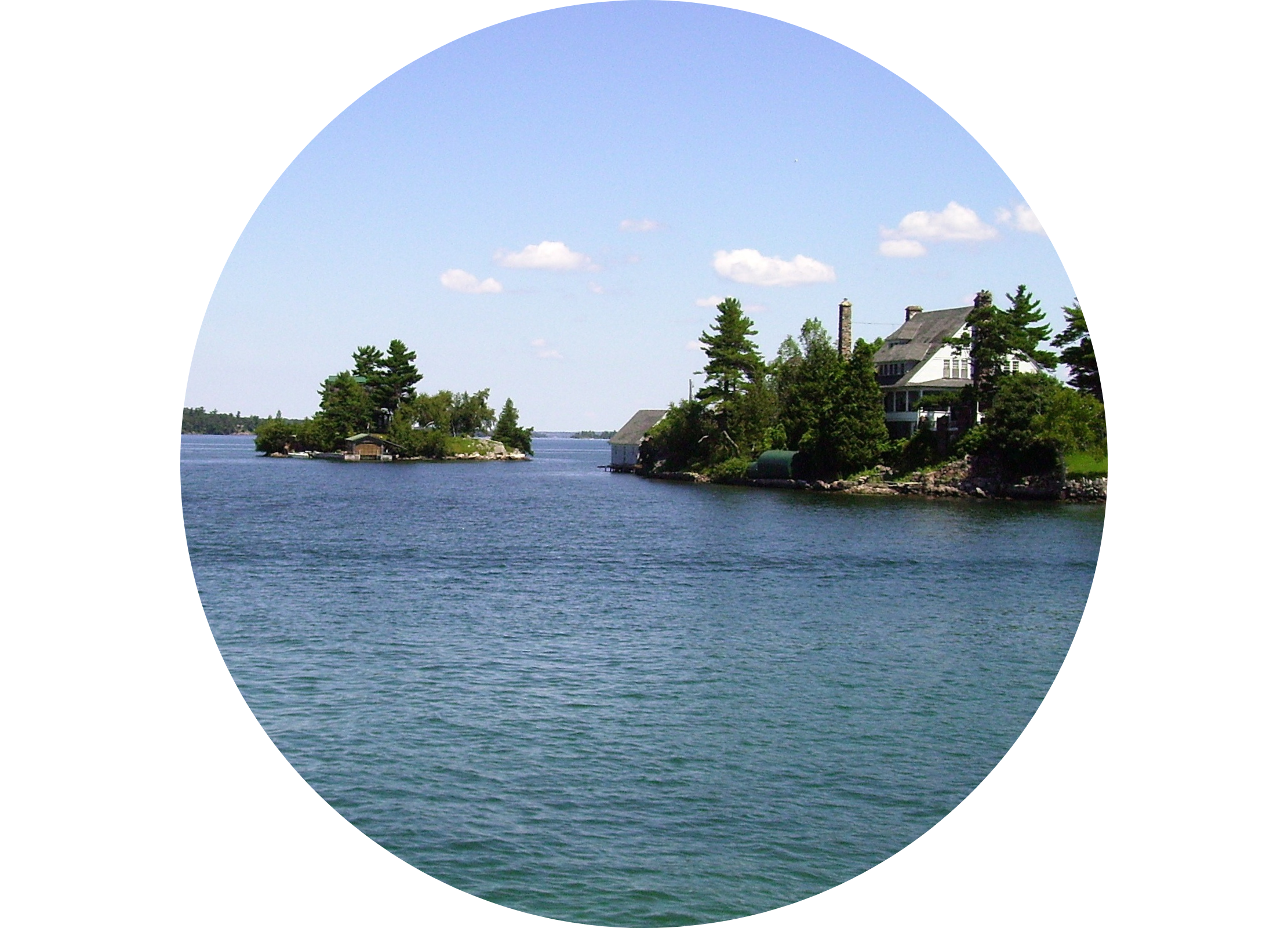 Kleines Haus auf einer bewaldeten Insel, umgeben von ruhigem, blauem Wasser