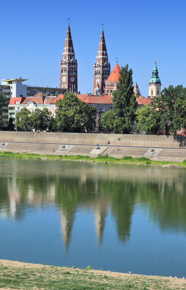 Stadtansicht mit Kirchtürmen, die sich im Fluss spiegeln aus Ungarn