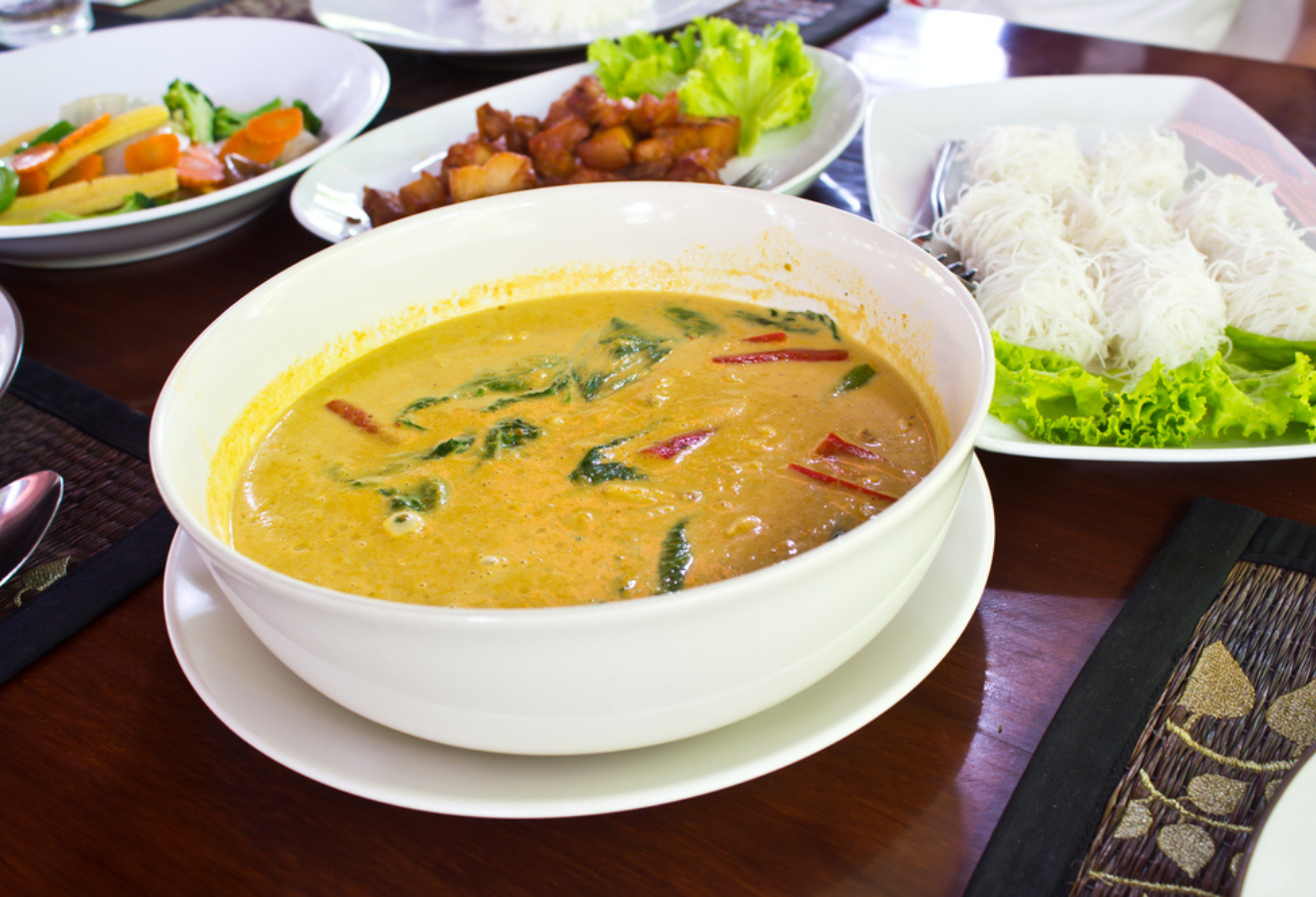 Currysoße mit Kokosmilch und Mango in einer weißen Schale