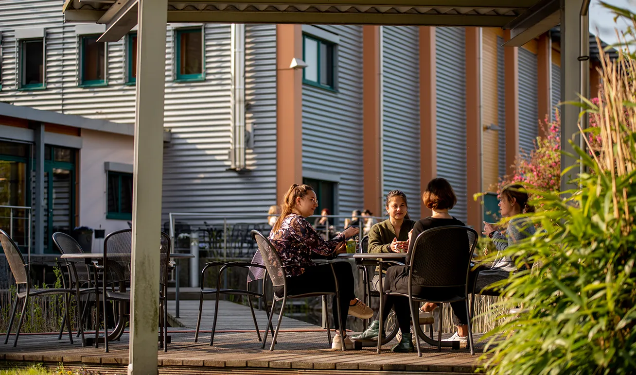 Menschen sitzen an einem Tisch im Außenbereich unseres Bistros in Diepholz