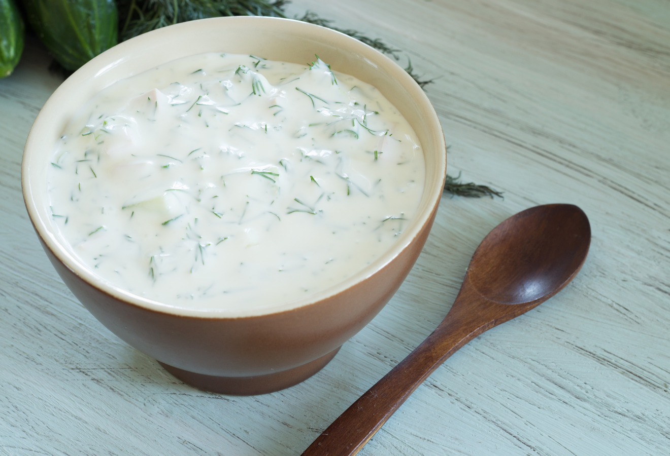 Joghurt-Marinade in einer Schale mit Holzlöffel daneben
