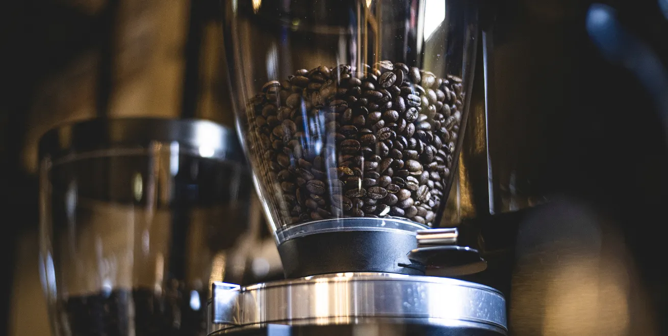 Nahaufnahme von Kaffeebohnen im Bohnenbehälter einer Kaffeemaschine
