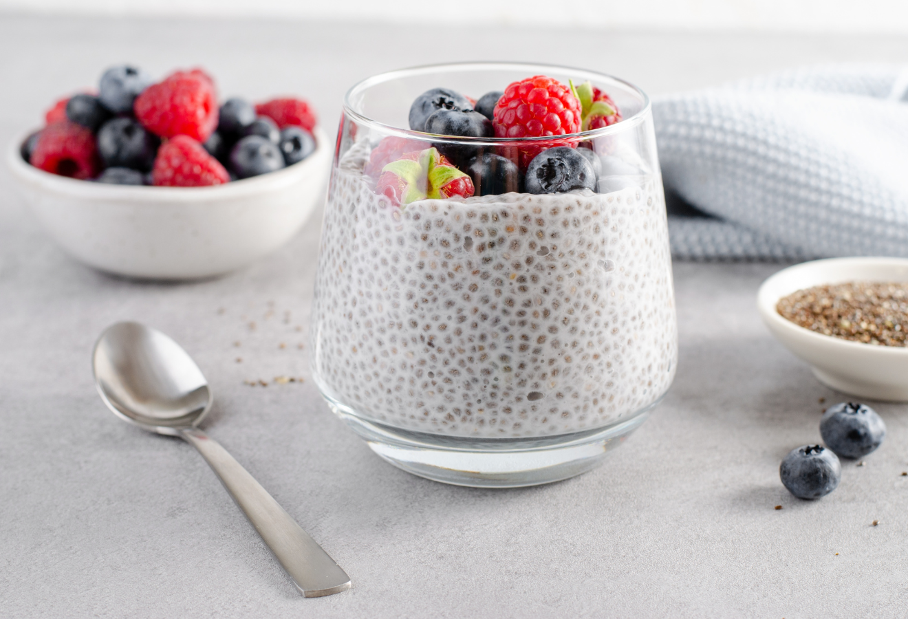 Beeren-Chia Frühstück im Glas mit Kokos mit Heidelbeeren und Himbeeren getoppt
