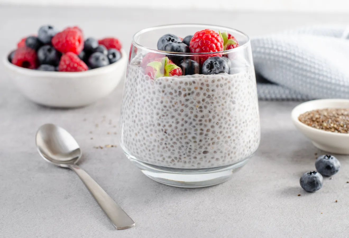 Beeren-Chia Frühstück im Glas mit Kokos mit Heidelbeeren und Himbeeren getoppt