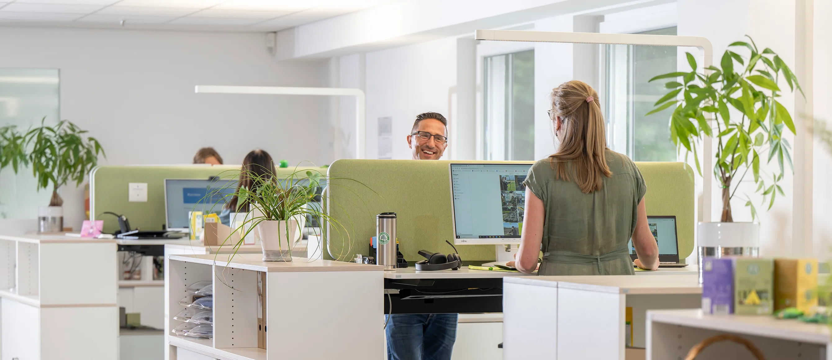 Menschen arbeiten an höhenverstellbaren Schreibtischen in unserem modernen Großraumbüro in Diepholz 